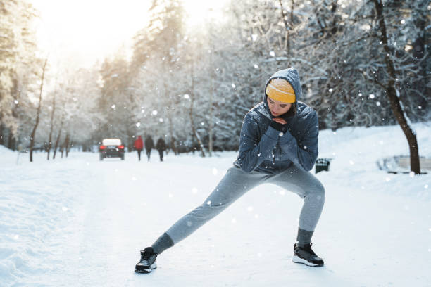 istock Young athletic woman warming up before her winter workout 1356437566