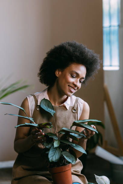 istock Smiling Female Florist Sitting in her Workshop Surrounded with Plants 1356438153