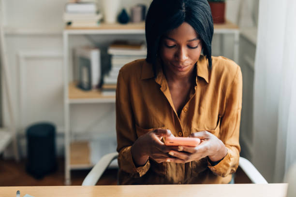 istock Cheerful Business Woman Using Mobile Phone at Home 1356438286