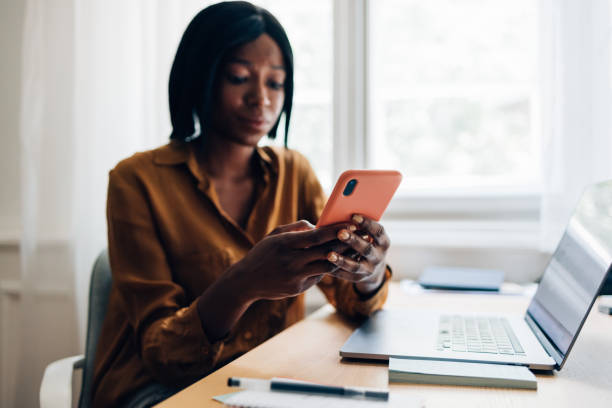 istock An Anonymous Business Woman Using Mobile Phone at Home 1356438296