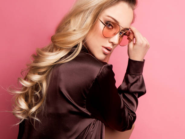 beautiful blond woman in a blouse and pants wearing glasses, holding handbag - fashion model pink beauty fashion imagens e fotografias de stock