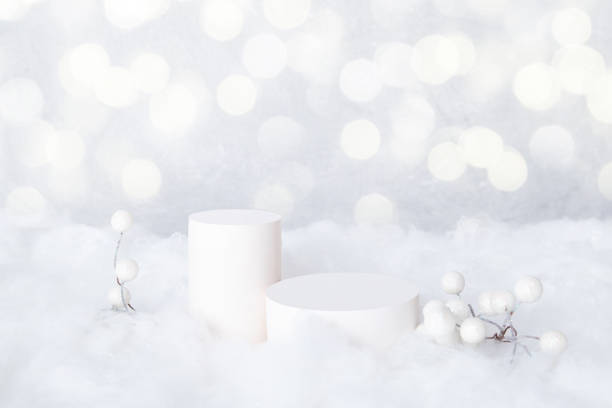 istock Mock-up podiums for cosmetics in the snow with decorative berries on bokeh background 1356439886