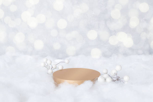 istock Podium mock-up for cosmetics in the snow with decorative berries on a bokeh background 1356439971