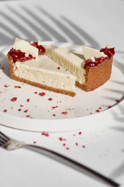 Sliced Cheesecake. Layer of biscuits, mousse based on creamcheese, with raspberry. Healthy dessert. Vegetarian food. Raw food. Raw dessert. Piece of cake.