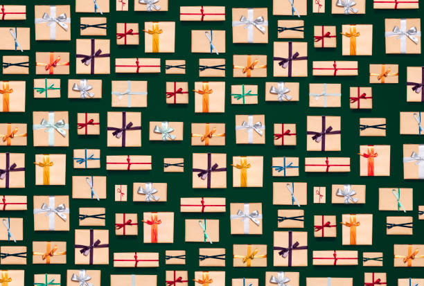 Directly above photo of wrapped xmas gifts in kraft paper on a green table.