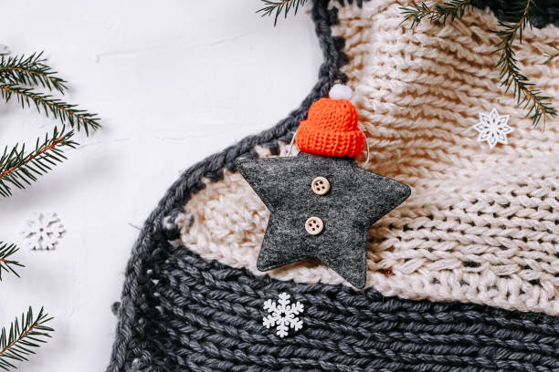 istock Minimalistic Christmas background. Knitted blanket and spruce branches and snowflakes on a white background 1356446236
