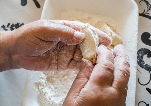 Closeup of woman kneading the dough on the table