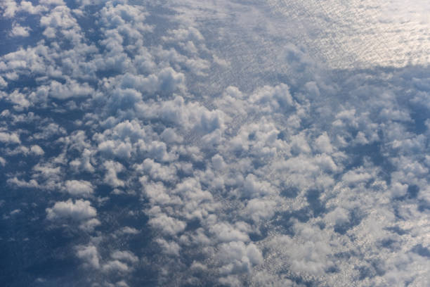istock Aerial evening sky and clouds view above ocean from airplane porthole. 1356446333