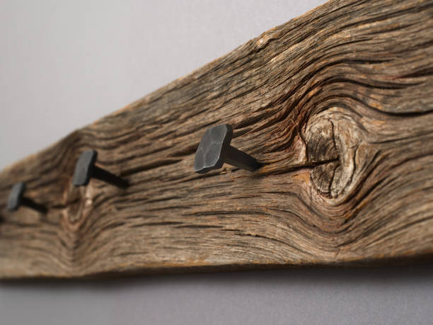 old coat rack, old board with hammered forged nails stock photo