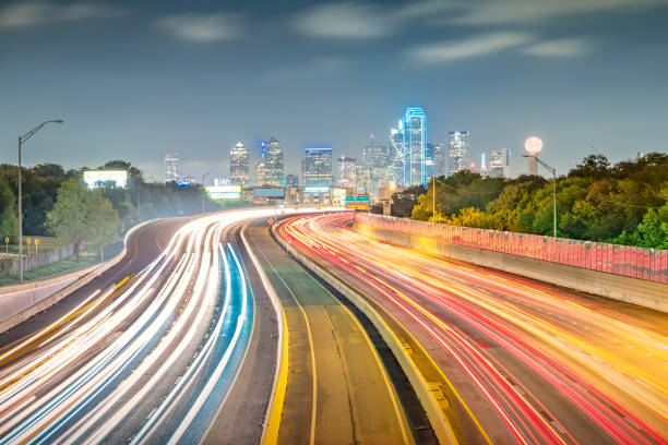 Long exposure of Interstate 30 with the downtown skyline of Dallas, Texas, USA in the background, at night.