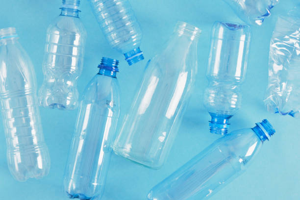 istock one glass bottle among several plastic bottles on a blue background 1356449917