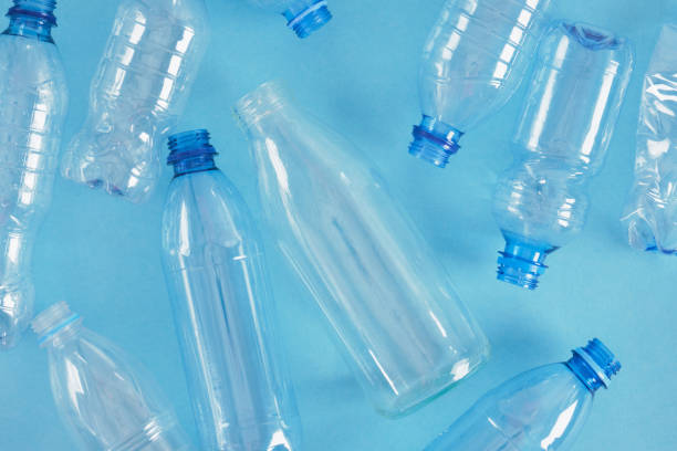 istock one glass bottle among several plastic bottles on a blue background 1356449923