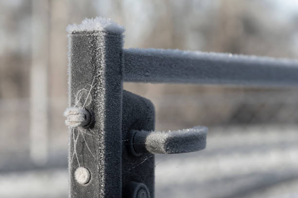Handle of open metal gate covered in ice crystals stock photo
