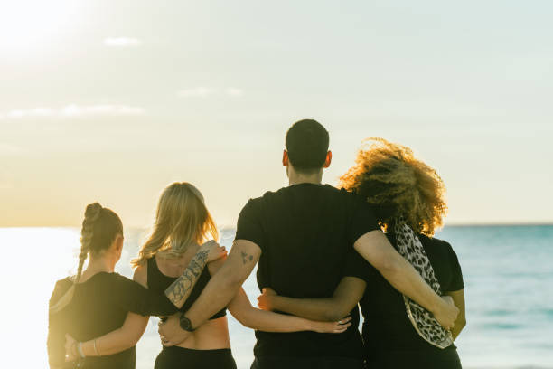 istock Back of a multiethnic yoga class group embracing for the back facing the sea 1356452052