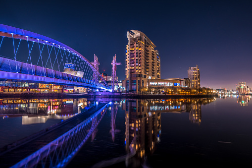 View of an illuminated footbridge in Salford quays during night in Manchester, England