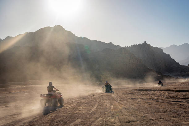 désert en afrique. excursions en egypte. charm el-cheikh. les touristes s’amusent sur des quads dans le désert sauvage. safari à vélo. sports extrêmes en été. - off road vehicle quadbike desert dirt road photos et images de collection