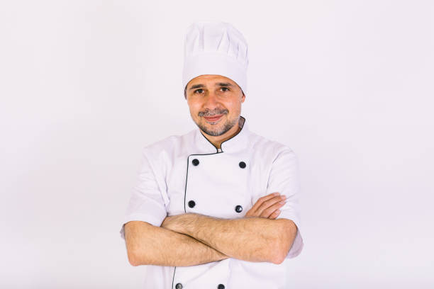 istock Chef cook wearing cooking jacket and hat, arms crossed, on white background 1356462124