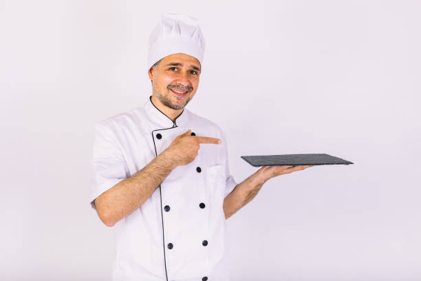 istock Chef cook wearing kitchen jacket and hat, holding a wooden tray, on white background 1356462240
