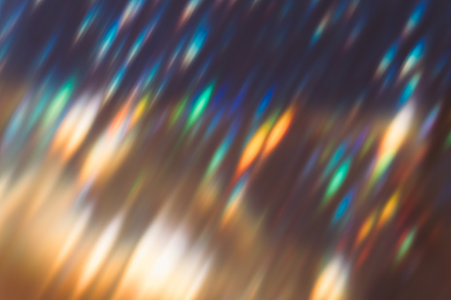 Lens flare overlay. Blur colorful glow. Optical glare leak. Party illumination rays. Defocused orange blue green light flecks on dark night abstract background.