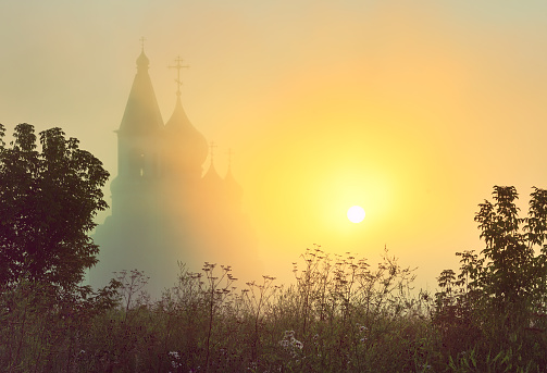 he silhouette of the Orthodox church in the middle of the green grass. Krasnoyarsk, Siberia, Russia