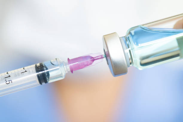 doctor's hand holds a syringe and a blue vaccine bottle at the hospital. Health and medical concepts. stock photo