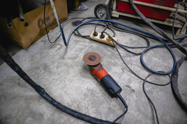 istock Hand grinders lay on the cement floor of the workshop. 1356483140