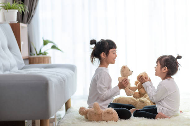istock Cute funny children playing with teddy bear at home 1356487029