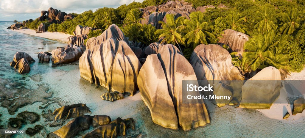 Anse Source d'Argent Beach La Digue Island Seychelles La Digue Anse Source d'Argent Beach. Drone Point of view over the famous Anse Source d'Argent Beach with it’s famous granite boulder rock formations and crystal clear ocean on La Digue Island. Stiched XXL Panorama in warm sunset light. Anse Source d'Argent is under the best-known beaches in the Seychelles. La Digue Island, Seychelles Islands, East Africa Seychelles Stock Photo