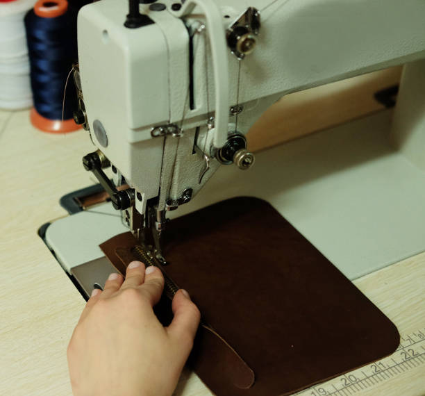 istock woman sewing leather handbag 1356488234