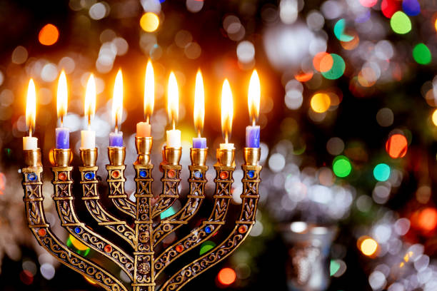 istock Menorah with burning candles for Hanukkah on sparkle background with defocused lights. 1356488384