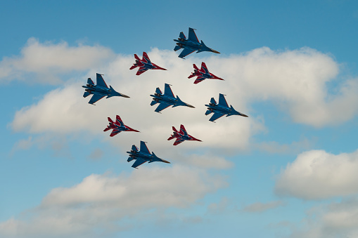 Moscow, Russia - May, 09, 2021: Diamond-shape of 4 Mig-29 The Russian Knights and 5 Su-27 Swifts in the sky over Red Square in the group Cuban Diamond. Aviation part of Victory parade in Moscow