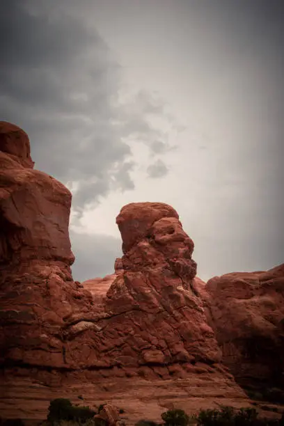 View of Face Made with Red Rock, storm clouds in the sky, Arches National Park, Utah, USA