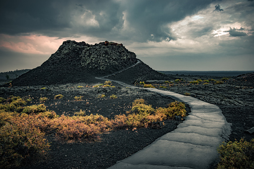 View of the spray cone trail on the horizon, lava hills, volcanic landscape at the National Reserve of the Moon and Craters, Idaho, USA