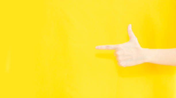 istock woman's finger pointing to copy space area for advertisement promotion or text on a yellow background 1356494093