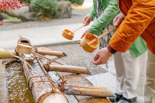 Senior couple cleaning their hands at a Japanese temple. Okayama, Japan