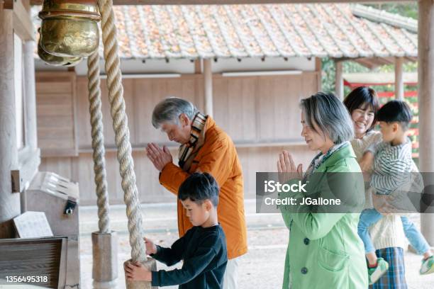 Multi Generational Family Praying At A Japanese Temple Stock Photo - Download Image Now