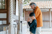 祖父は孫と一緒に日本のお寺で祈る
