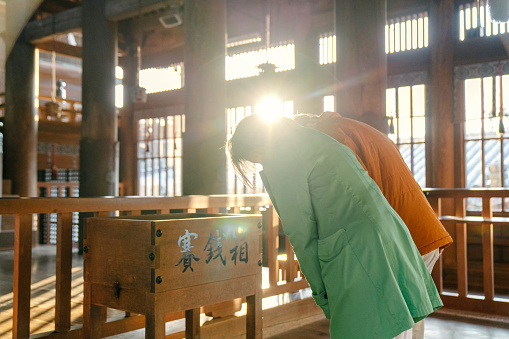 Senior couple praying a Japanese temple for Hatsumode. Okayama, Japan