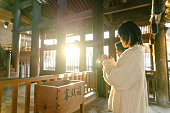 初詣の日本のお寺で祈る先輩女性とその娘