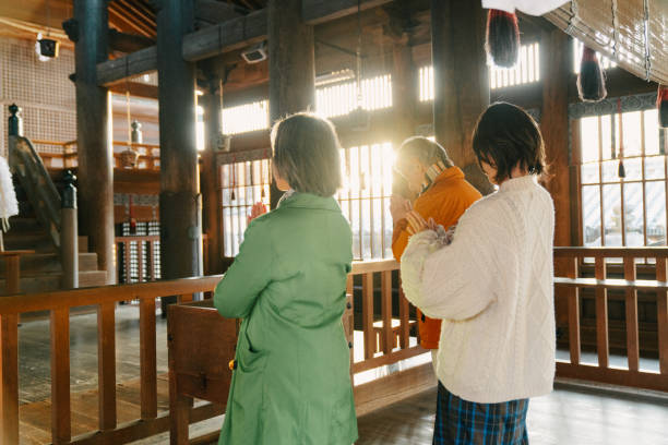 dorosła rodzina modląca się za hatsumode w japońskiej świątyni - winter women zen like photography zdjęcia i obrazy z banku zdjęć