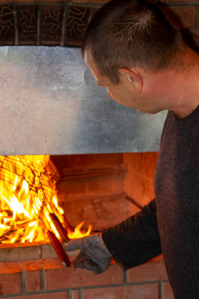 istock man doing barbecue, grilling kebabs on the fire in the oven 1356498307