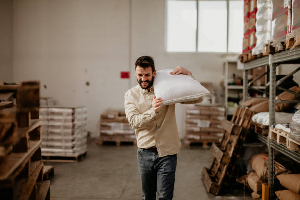 istock Cheerful warehouse worker carrying a bag 1356501265