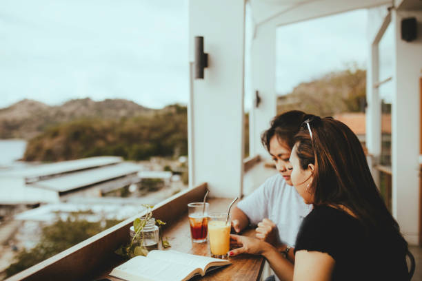 istock asian woman taking drink and talking in cafe 1356501801