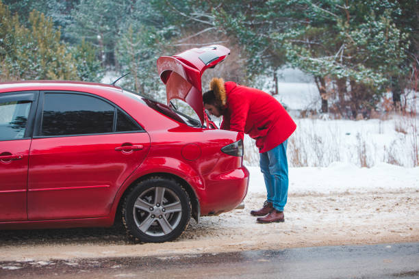 istock man looking in car trunk at snowed roadside 1356502593