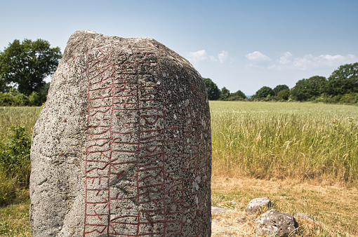 One of the old rune stones (runsten) in the open landscape of Öland. Summer time. 2021.