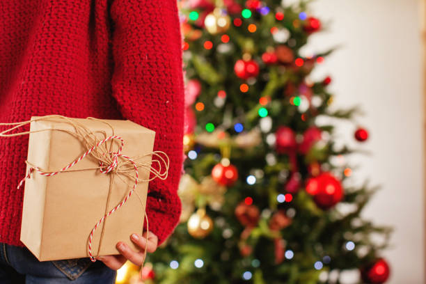 istock Child near the Christmas tree with a gift behind 1356509685