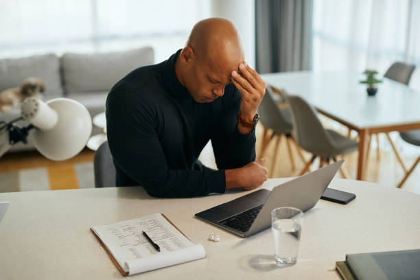 istock Young black entrepreneur having headache while working on laptop at home. 1356510481