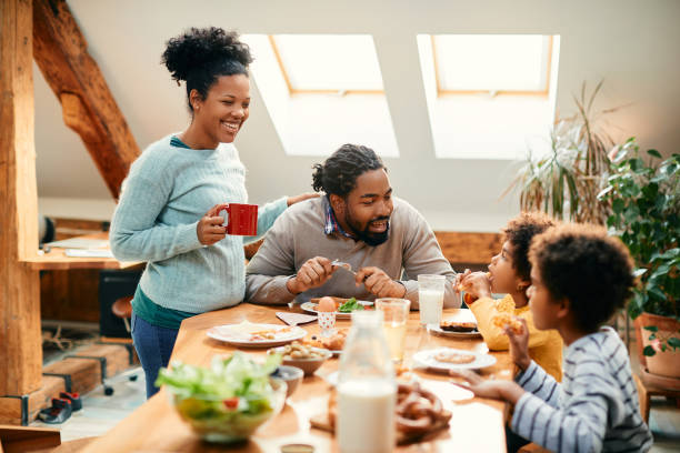 istock Happy black family talking while having breakfast together at dining table. 1356510537