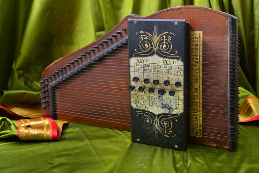 The harmonica rests on the body of a classical guitar. Classical musical wind instrument.