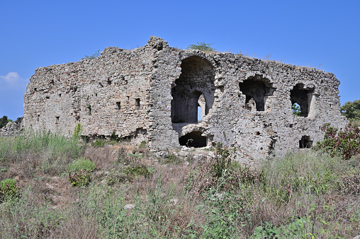 An ancient Roman building made of gray bricks. Roof, windows and doors are missing.